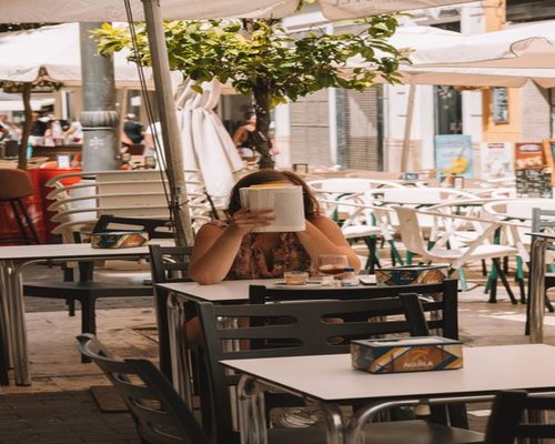 Woman enjoying a relaxed morning coffee on a sunny Spanish terrace